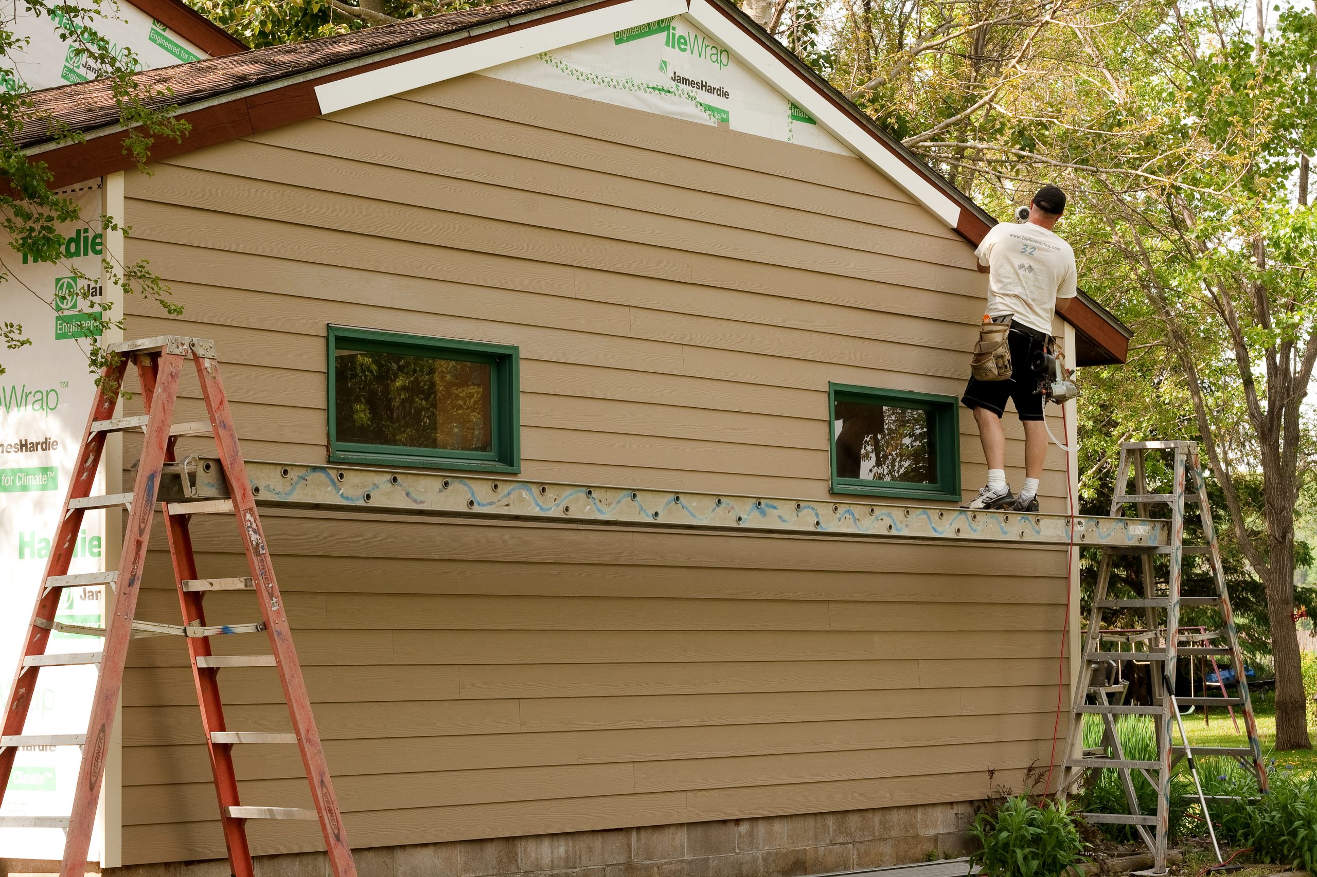 Professional team installing Hardie Board siding on a home in Greater Houston, demonstrating precise craftsmanship and attention to detail.